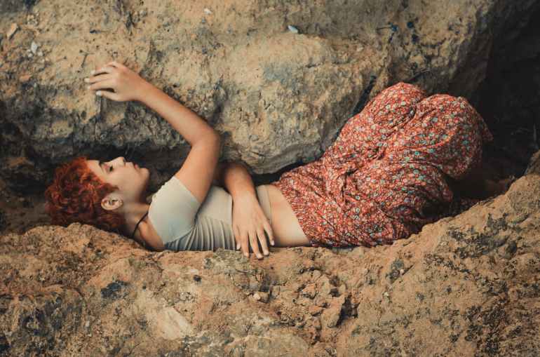 woman lying in between boulders