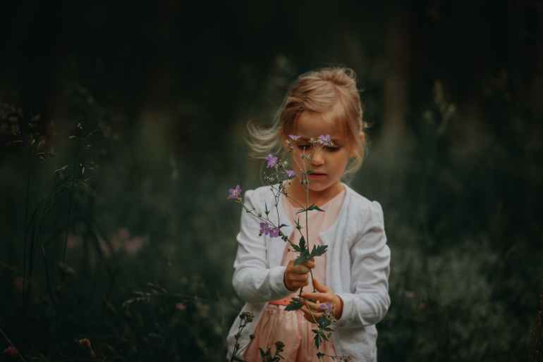 girl holding flowering plants