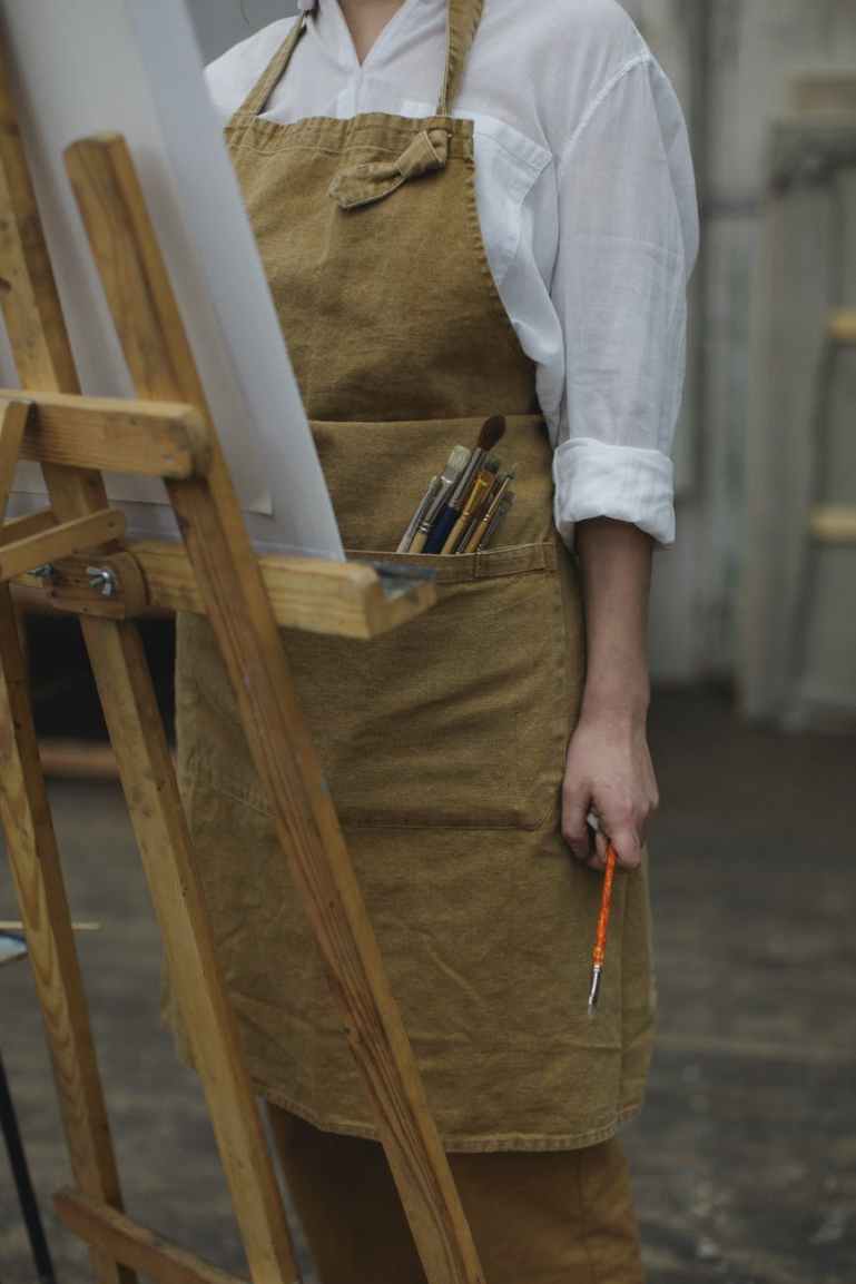 person in white long sleeve shirt holding paint brush