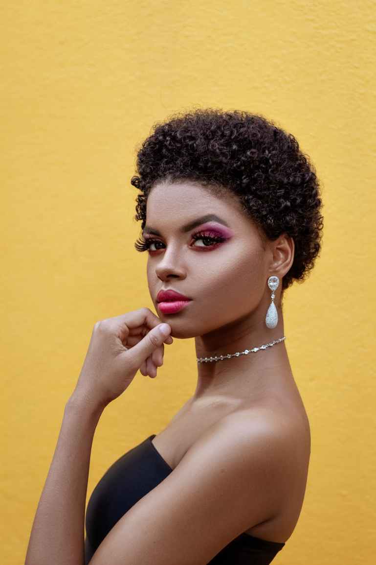 woman standing next to yellow wall