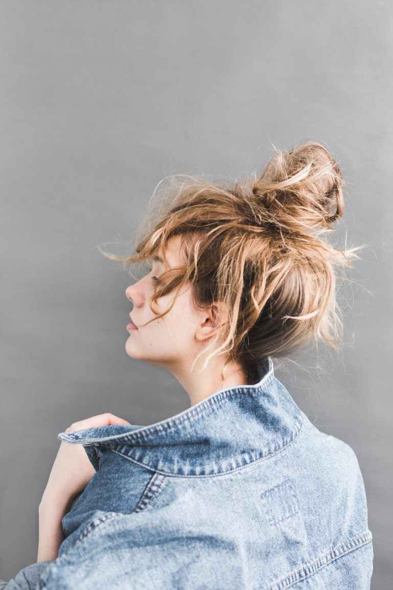 back view of woman holding her denim jacket