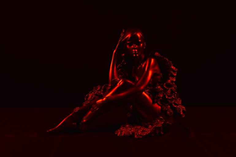 woman sitting and touching head statue