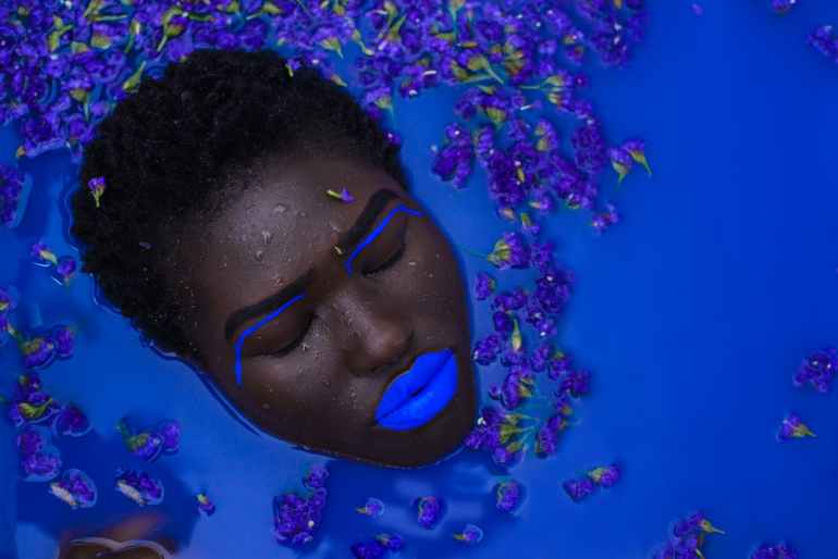 woman with blue lips on body of water