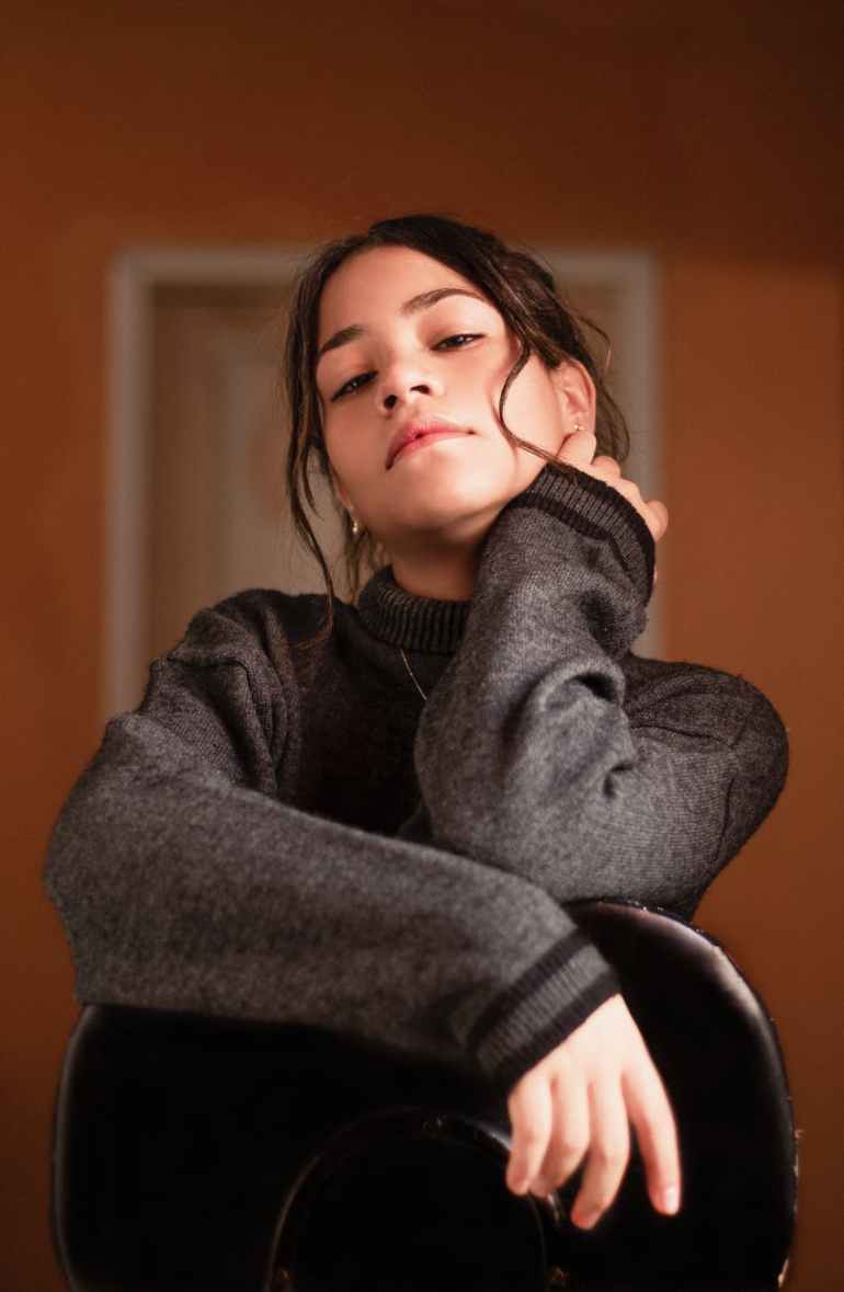 girl wearing gray turtleneck sweater holding neck