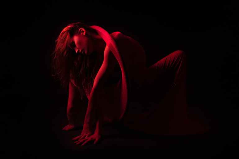 bending woman in dark room