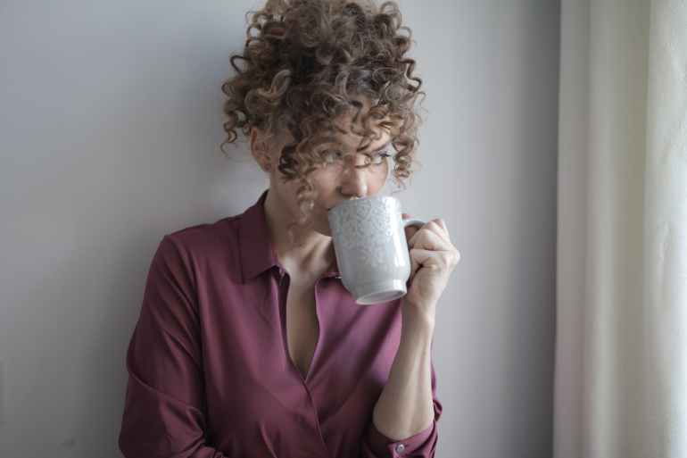 woman drinking coffee at home in solitude